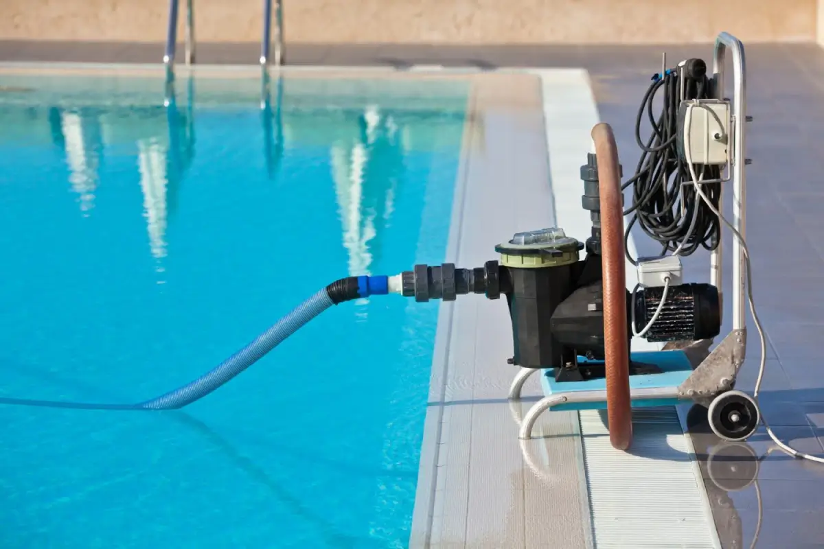 Pool cleaning equipment with a hose connected to a swimming pool for maintenance.