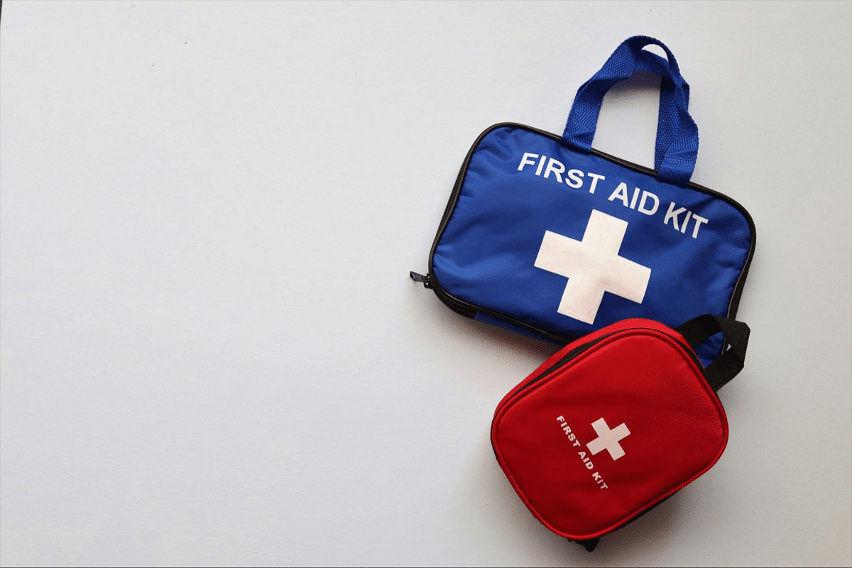 Two first aid kits, one blue and one red, placed on a white surface.